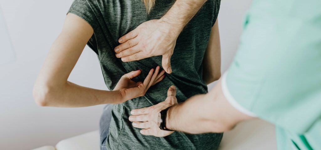 Personne assise sur une table de massage, recevant un soin ostéopathique, illustrant les moments opportuns pour consulter un ostéopathe en cas de signaux d'alerte corporels.