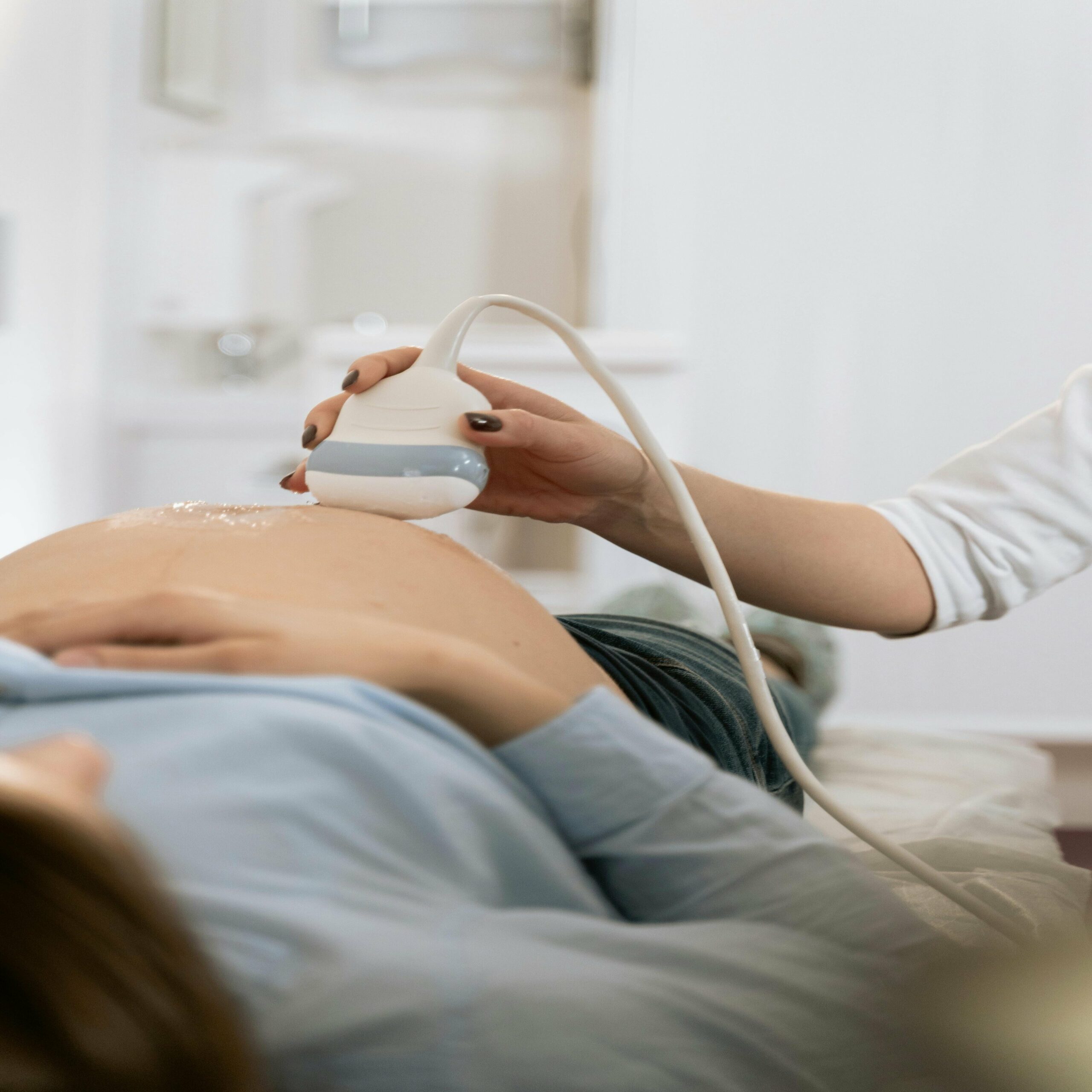 Une femme enceinte allongée sur une table avec une sonde d'échographie.