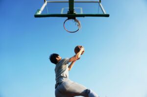 Photo d'un homme amenant un ballon de basket au panier
