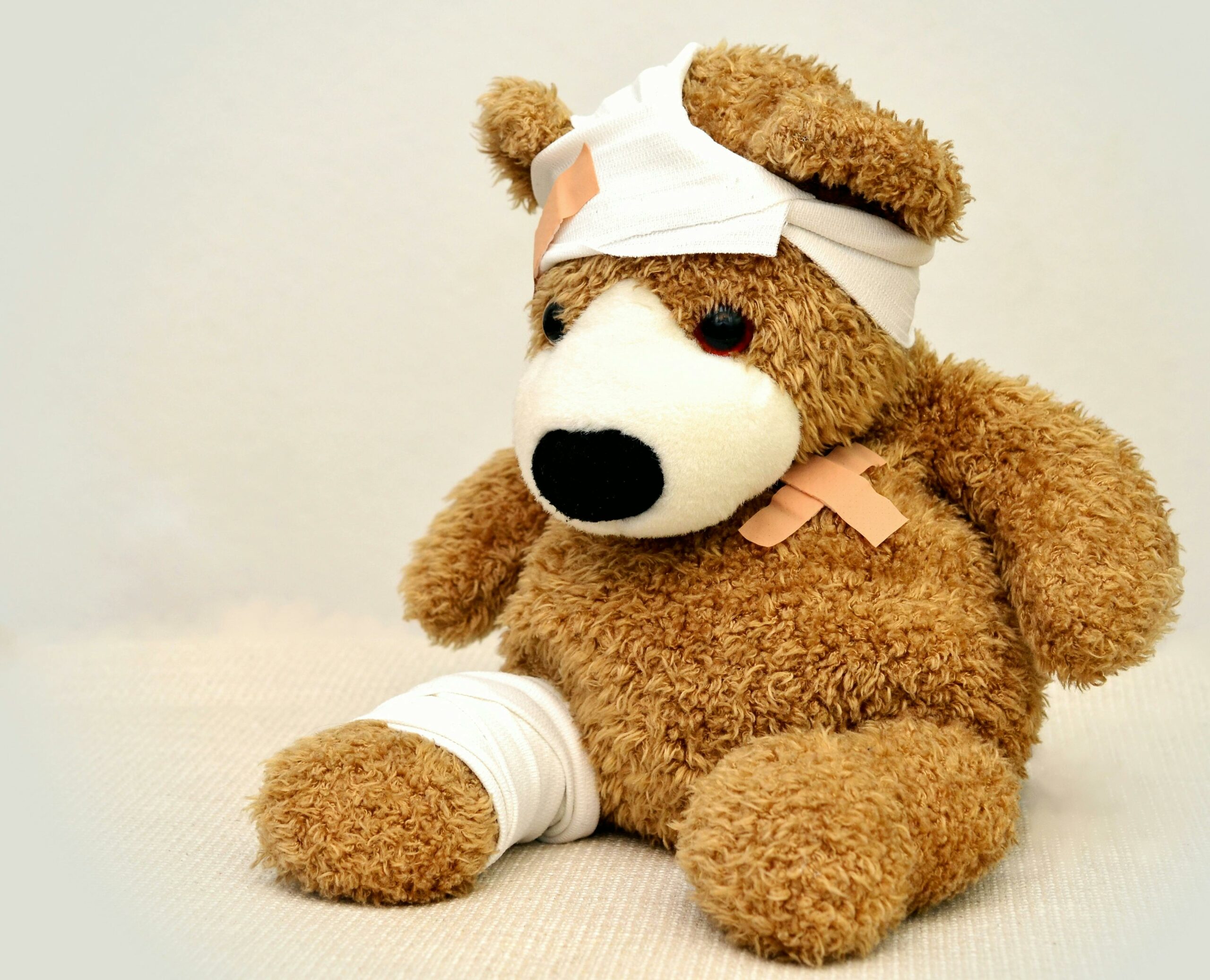 Image d'un ourson en peluche portant des bandages suite à des blessures.