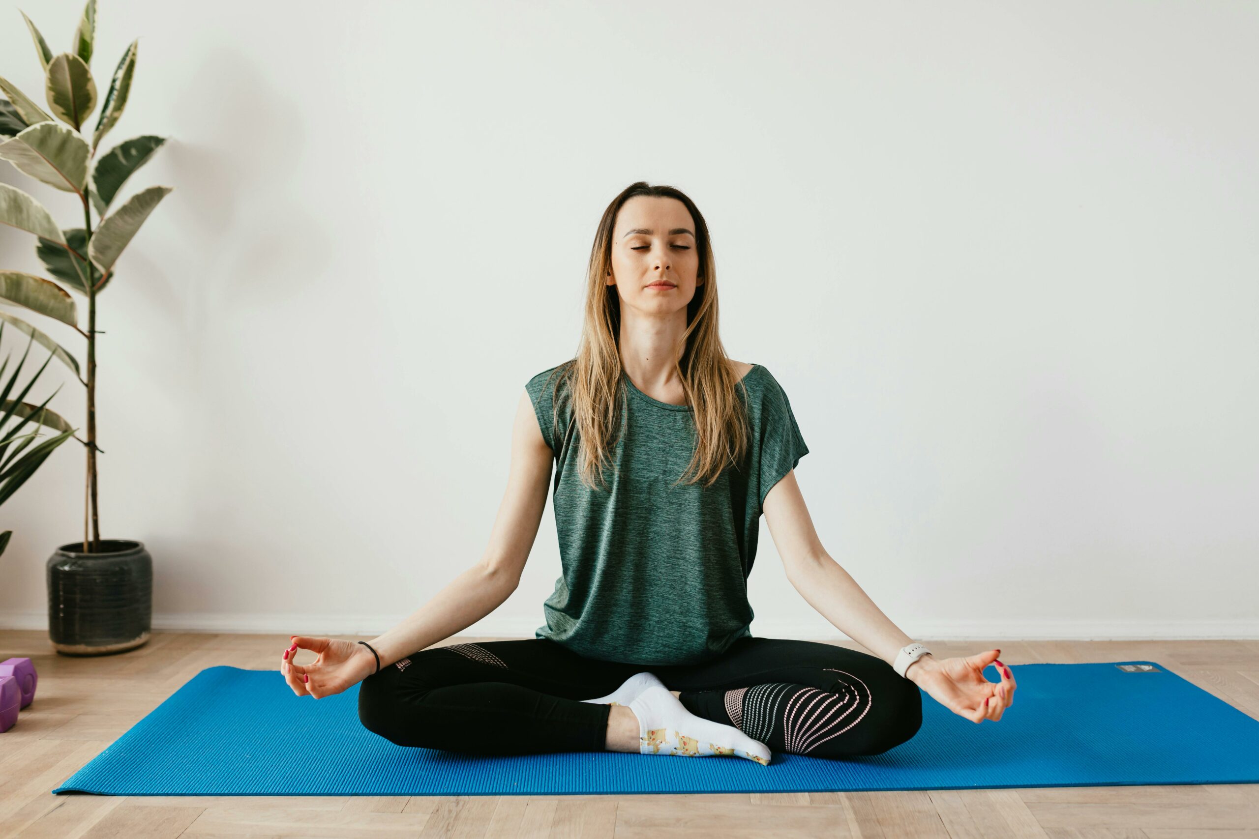 Femme pratiquant une pose de yoga relaxante dans un environnement apaisant, illustrant les bienfaits de l’ostéopathie sur la gestion du stress et la détente corporelle.