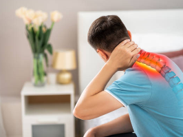 Une homme se tenant la base de la tête qui lui fait mal.
